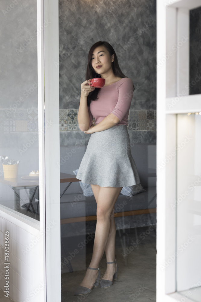 Woman at window with coffee