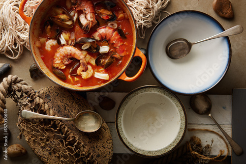 Seafood stew served in bowls in a rustic table setting. photo