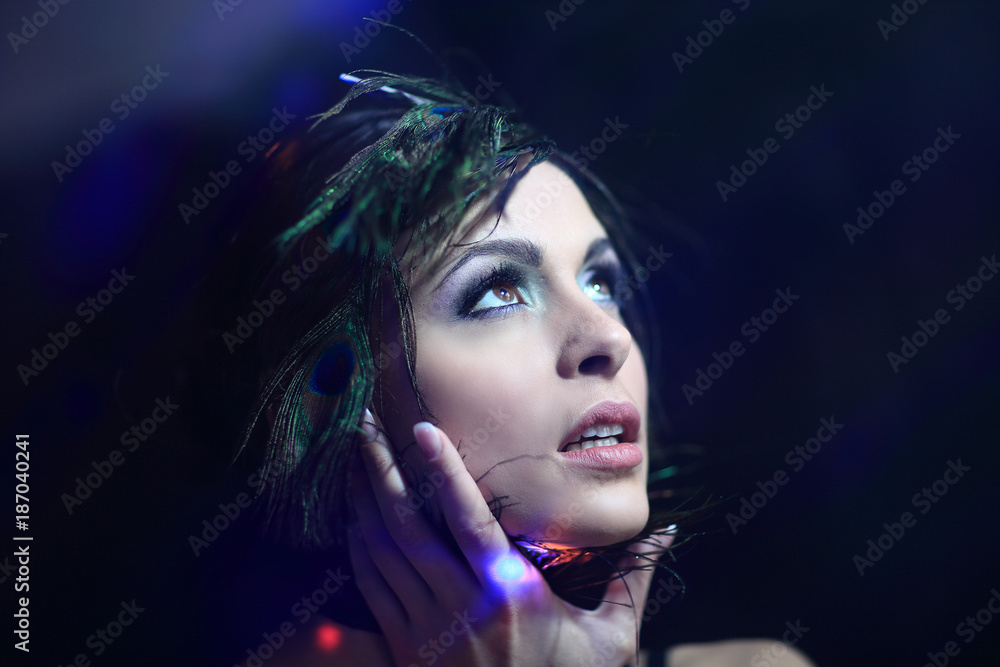 Naklejka premium Beautiful black-haired woman with peacock feathers in studio sho