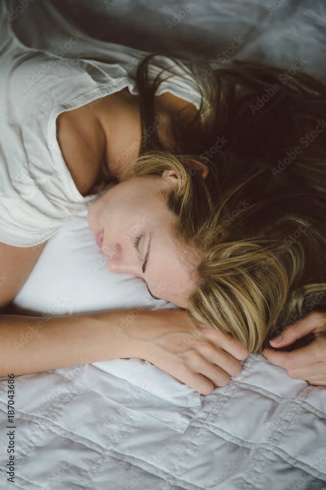 Top view of woman sleeping belly down on her bed. Top view of woman sleeping belly down on her bed.