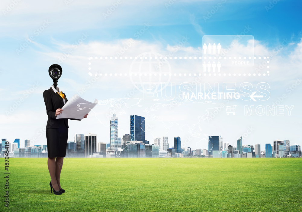 Camera headed woman standing on green grass against modern cityscape Camera headed woman standing on green grass against modern cityscape