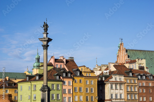 Colorful tenement houses and the Sigismund's Column at the Castle Square in Warsaw, Poland. Picturesque old town under a clear blue sky.