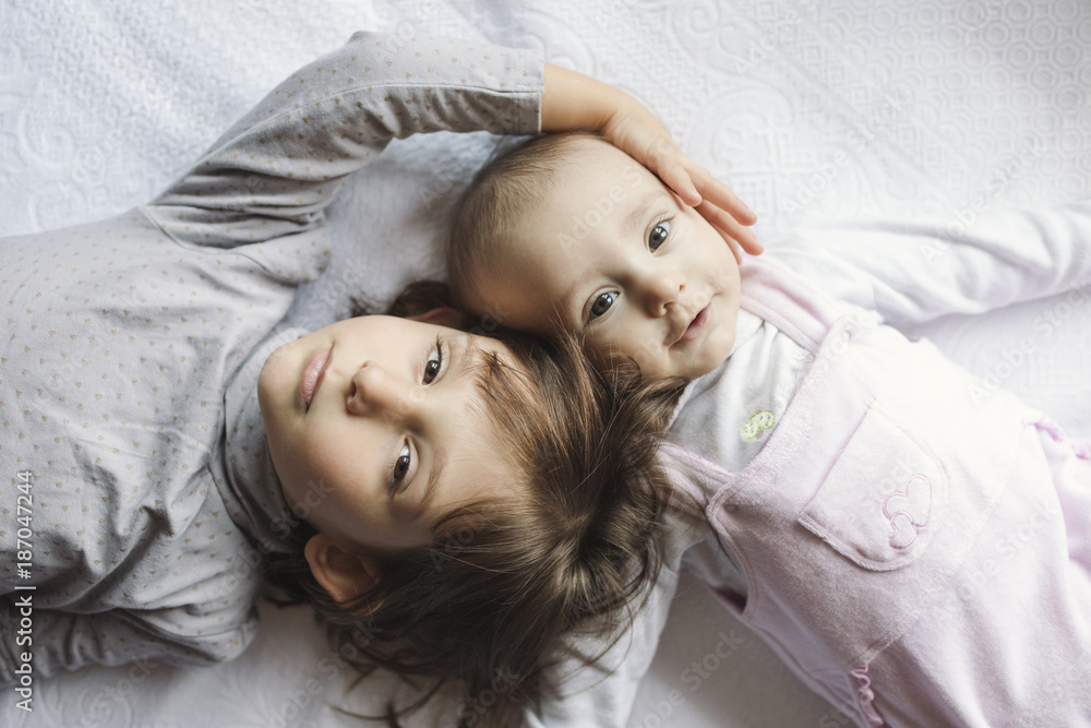 Portrait of two little sisters lying down Portrait of two little sisters lying down