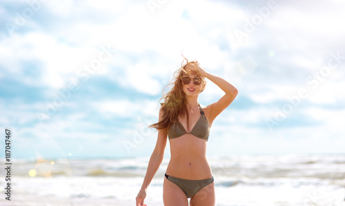 happy girl on the beach with a beautiful figure in a swimsuit. a trip to the sea around the world 