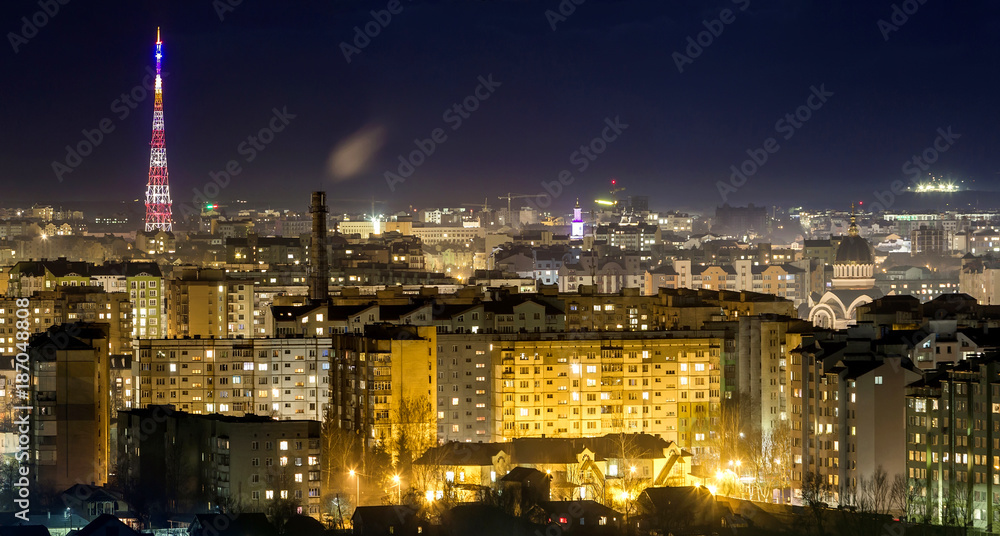 Fototapeta premium Panorama of night aerial view of Ivano-Frankivsk city, Ukraine with bright lights and high buildings.