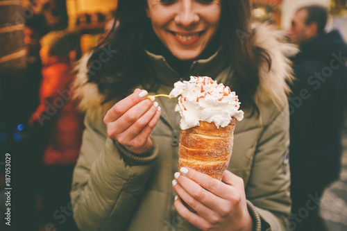 Photography trdelnik or Trdlo with cream in the hands of a beautiful winter girl in the Czec