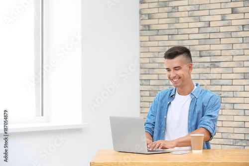 Young man using laptop in o...