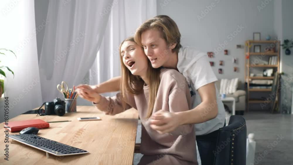 A couple is spending time together. They are making fun in a big white room. A couple is spending time together. They are making fun in a big white room.