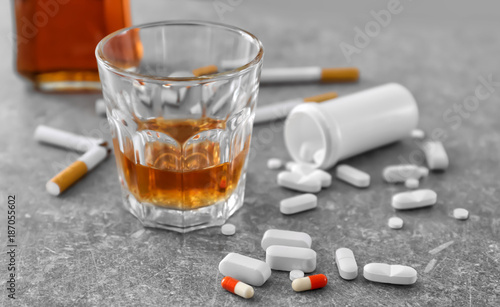 Glass of alcohol, cigarettes and drugs on table. Concept of bad habits
