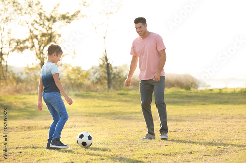 Father and his son playing soccer in countryside © Africa Studio