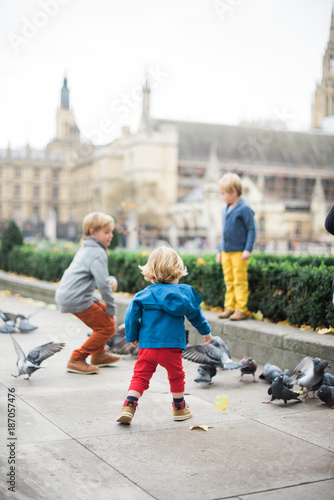 Family Feeding Pigeons in Historic London Square