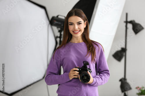 Beautiful young photographer with camera in professional studio © Africa Studio