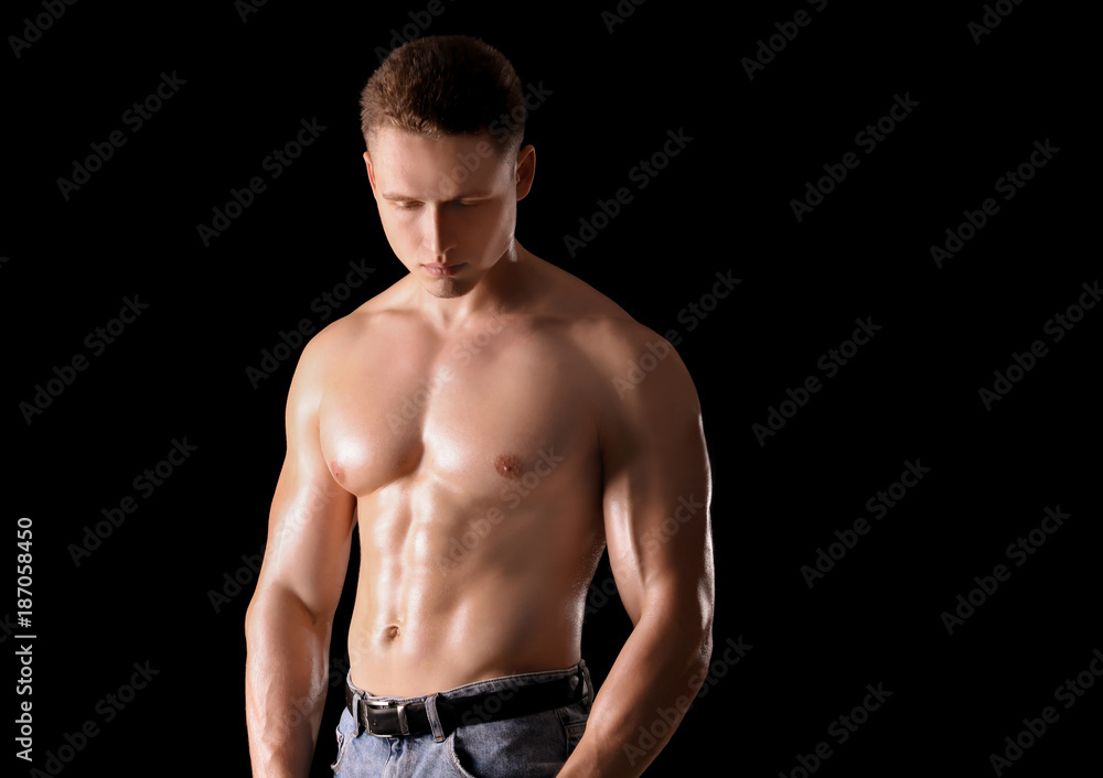 Muscular young bodybuilder on dark background Muscular young bodybuilder on dark background