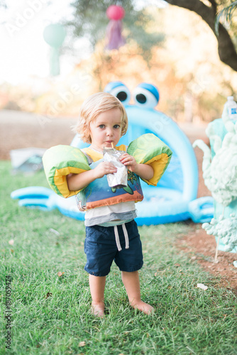 Child in Swimming Suit and Floaties Drinking
