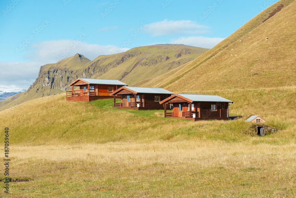 Three Cabins sitting on a Grassy Hill
