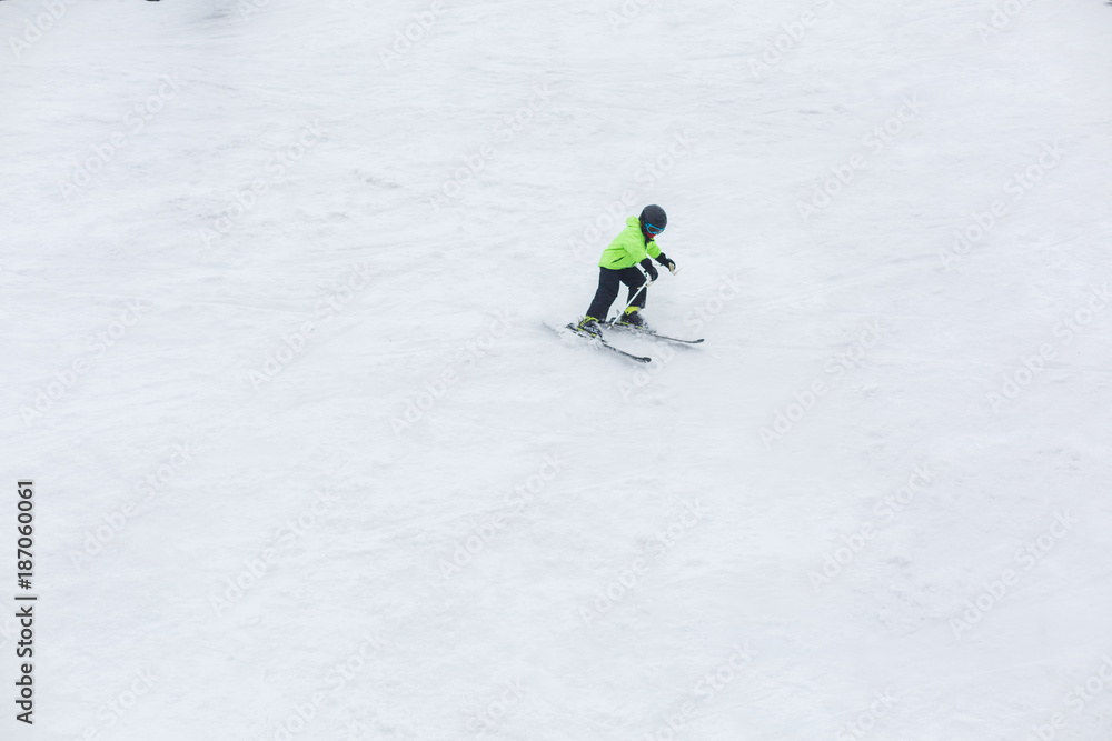 The child is skiing alone.