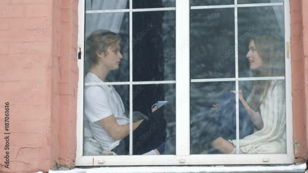 Two belovers at the window on the foreground. Intimacy is between them. Two belovers at the window on the foreground. Intimacy is between them.