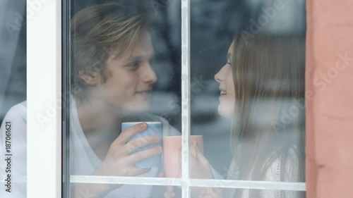 Carefree timespending. Sitting on the window sill with colorfull coffee cups speak about their relationships.