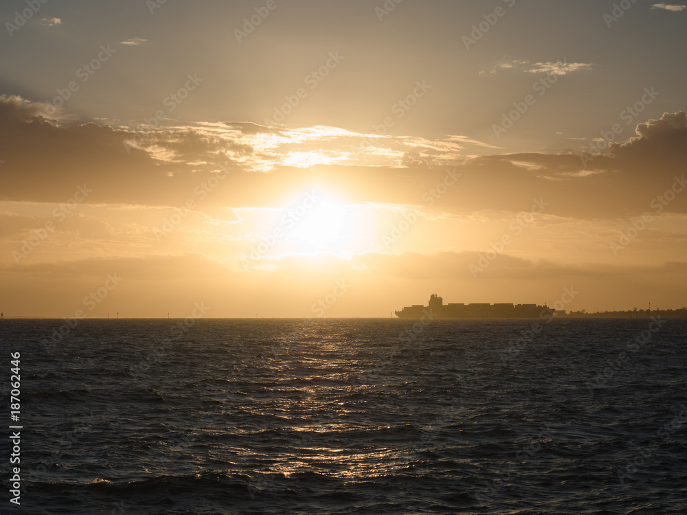 A ship passes as the sun sets in Melbourne, Australia.