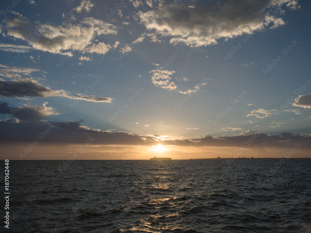A ship passes as the sun sets in Melbourne, Australia.