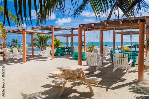 CAYE CAULKER, BELIZE - MARCH 2, 2016: Swing chairs at a beach in Caye Caulker village, Belize photo