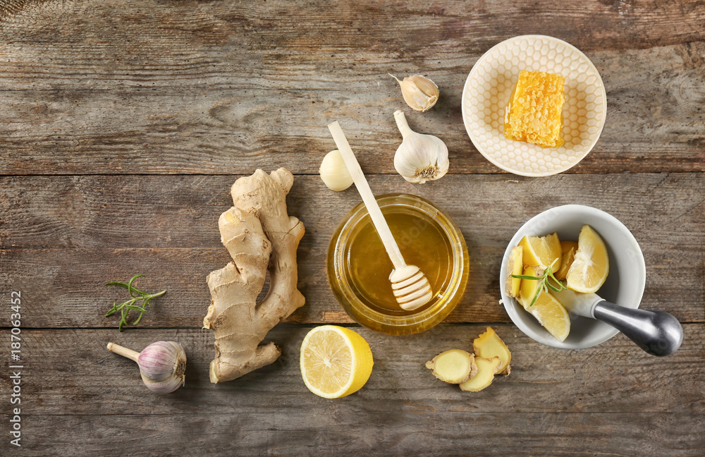 Composition with honey and garlic as natural cold remedies on wooden background, top view Composition with honey and garlic as natural cold remedies on wooden background, top view