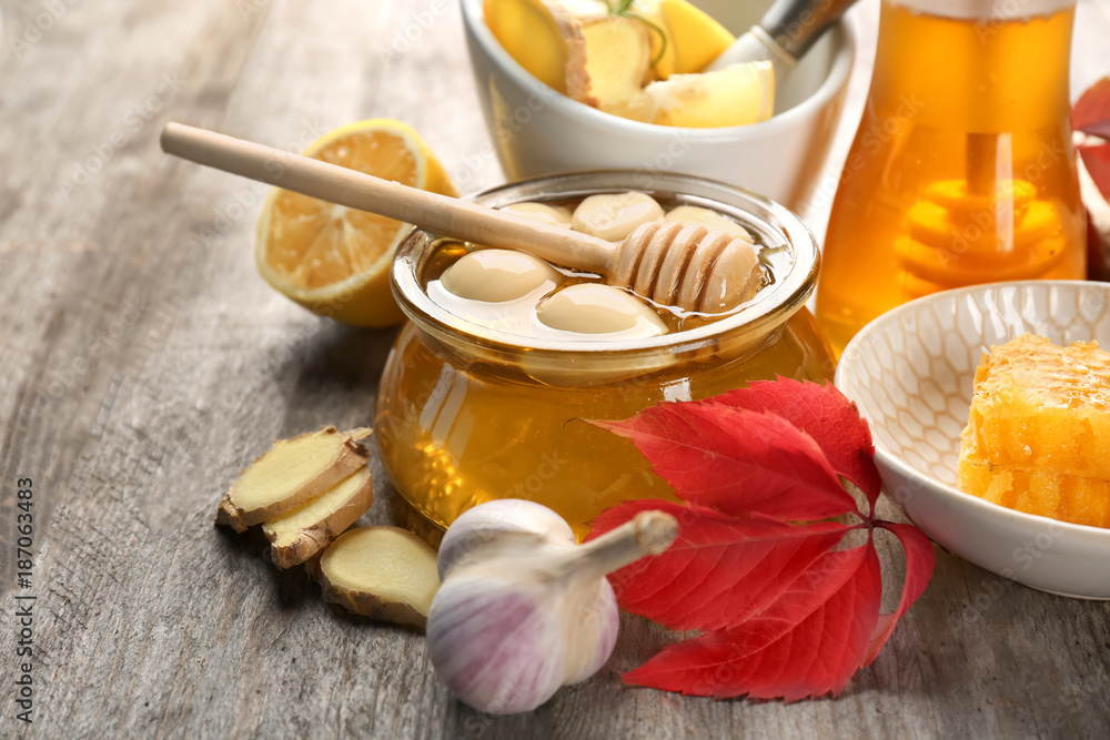 Composition with honey and garlic as natural cold remedies on wooden background Composition with honey and garlic as natural cold remedies on wooden background