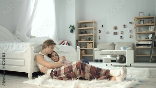 Romantic picture of loving people. Sitting on the bushy capret at the bed and holding each other. photo