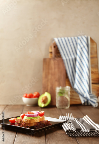 Plate with delicious sandwich on table