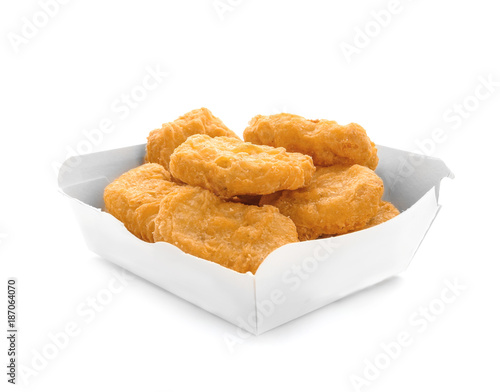 Box with tasty chicken nuggets on white background photo