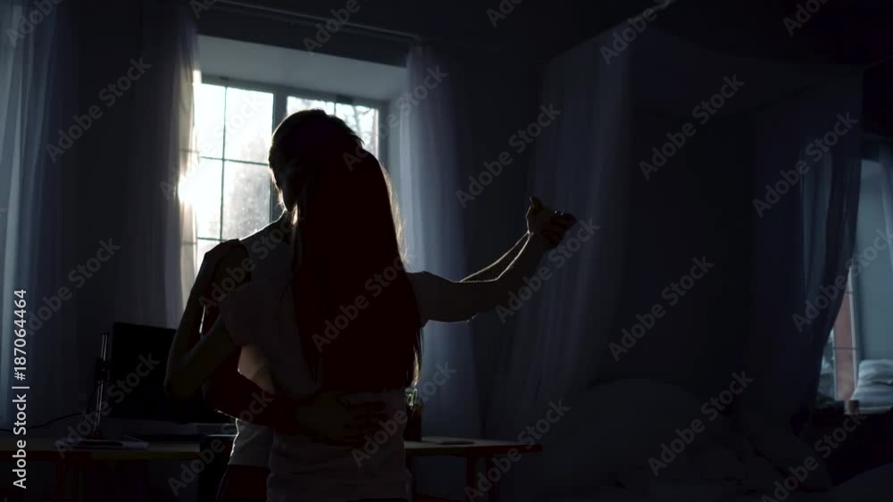Silhouettes of dancing couple in the middle of te room. Training of wedding dance. Silhouettes of dancing couple in the middle of te room. Training of wedding dance.