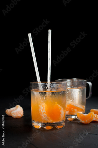 orange drink, tangerines and lemon on a dark background © Olena