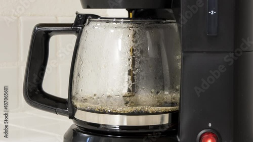 Coffee maker pot filling close up time lapse.