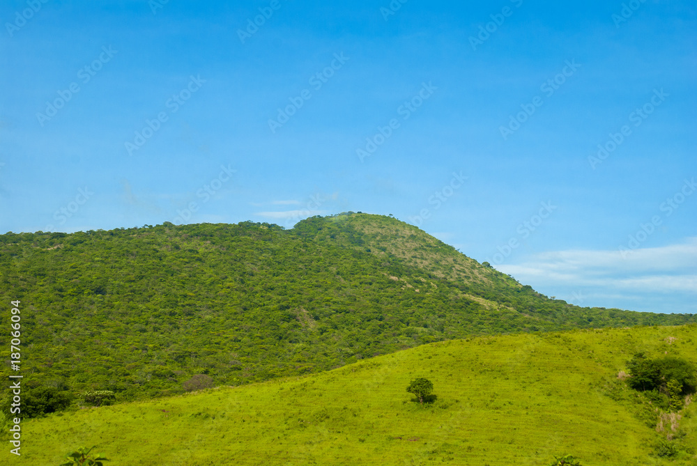 Summer landscape with mountains, cloudy sky, green grass and trees in Guatemala.