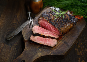 Fototapete Steakhouse Gegrilltes Steak mit Rosmarin Schneidebrett  © venge