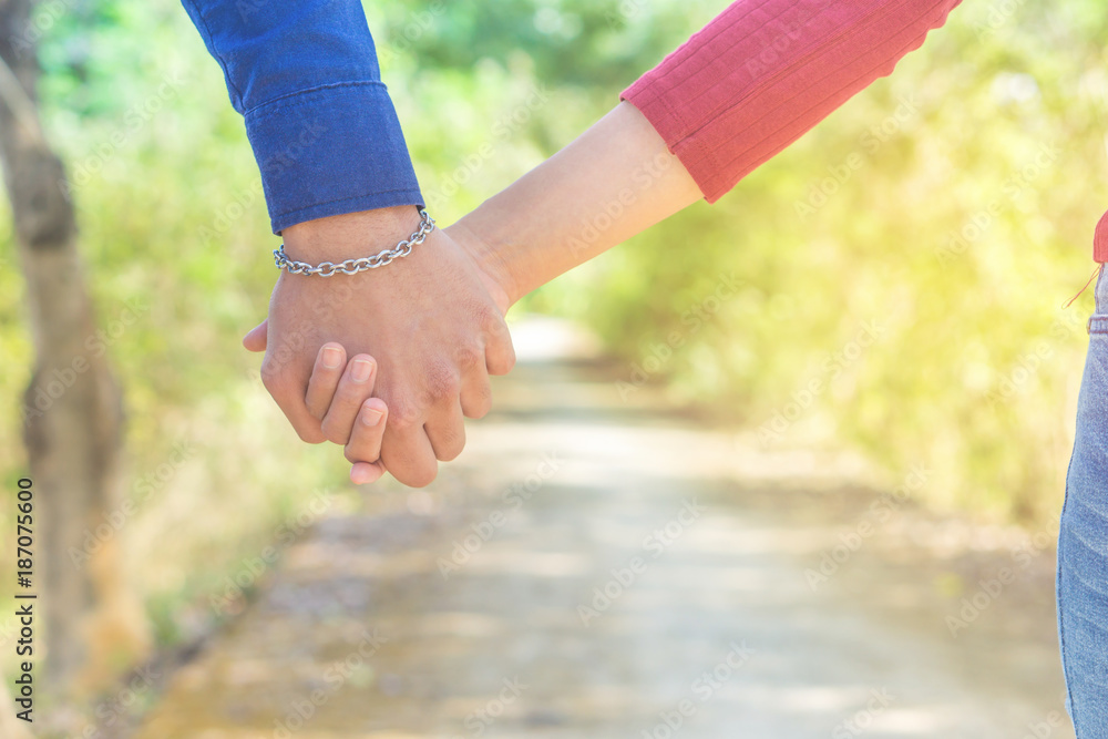 young couple in love holding hand together walking in a beautiful park with  romantic nature background Stock Photo | Adobe Stock