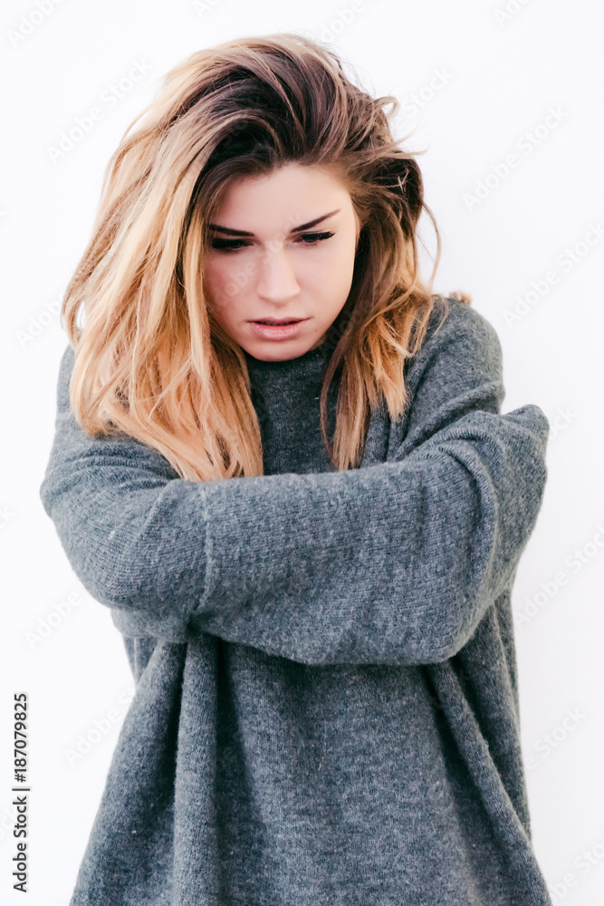 girl in gray sweater hugs herself by waist warming herself girl in gray sweater hugs herself by waist warming herself