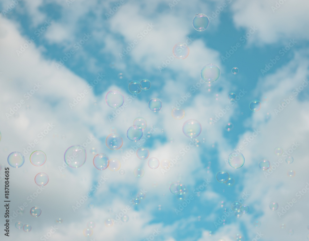 Abstract background : Beautiful soap bubbles reflecting various color floating on sky and white cloud background. Filter color : Aqua.