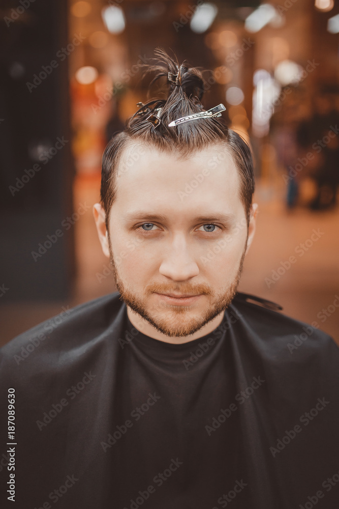 Barbershop. man in a hairdresser is preparing barber to cut hair with hairpin clips. Barbershop. man in a hairdresser is preparing barber to cut hair with hairpin clips.