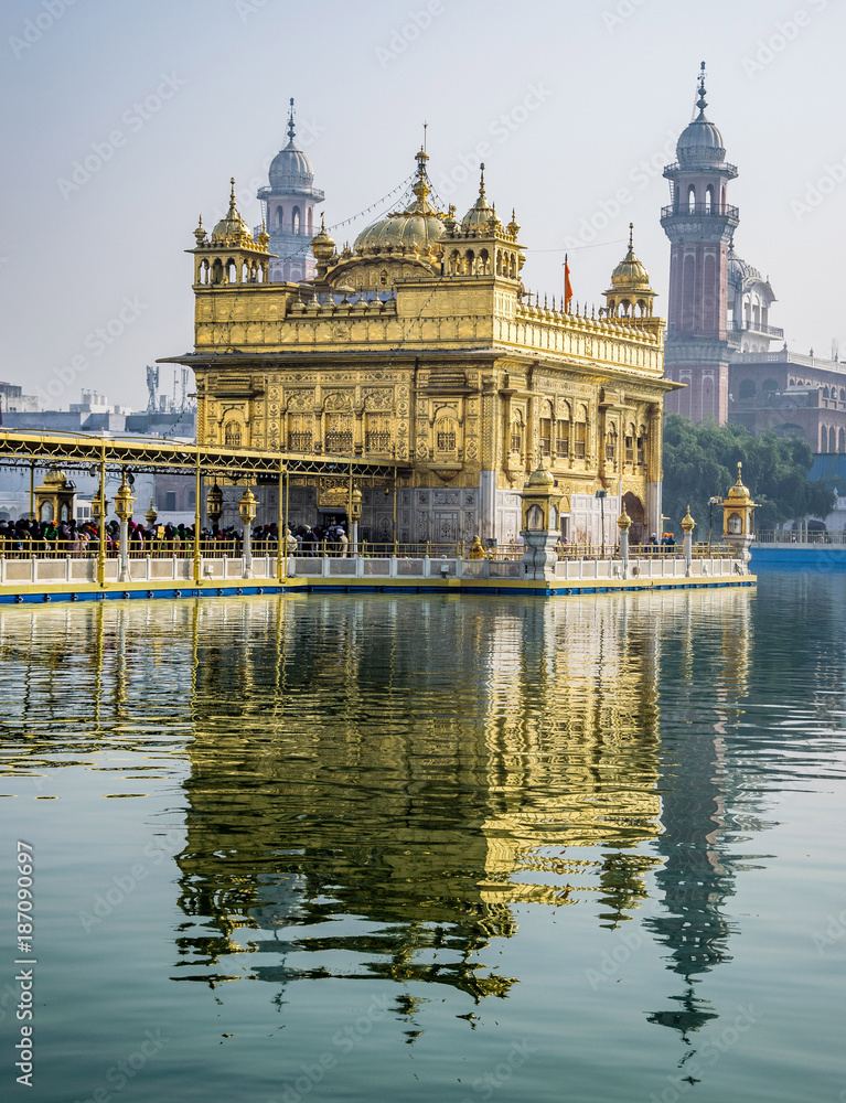 Golden Temple, Sikh Gudwara in Amritsar, India. .Reflections on sacred pond of Harmandir Sahib, holiest shrine of the Sikh religion. Famous Indian landmark on sunny day.