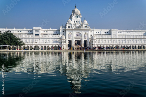 White building of Central Sikh Museum, Amritsar, India. .Reflection of famous Indian landmark at the water of sacred pond on sunny day.