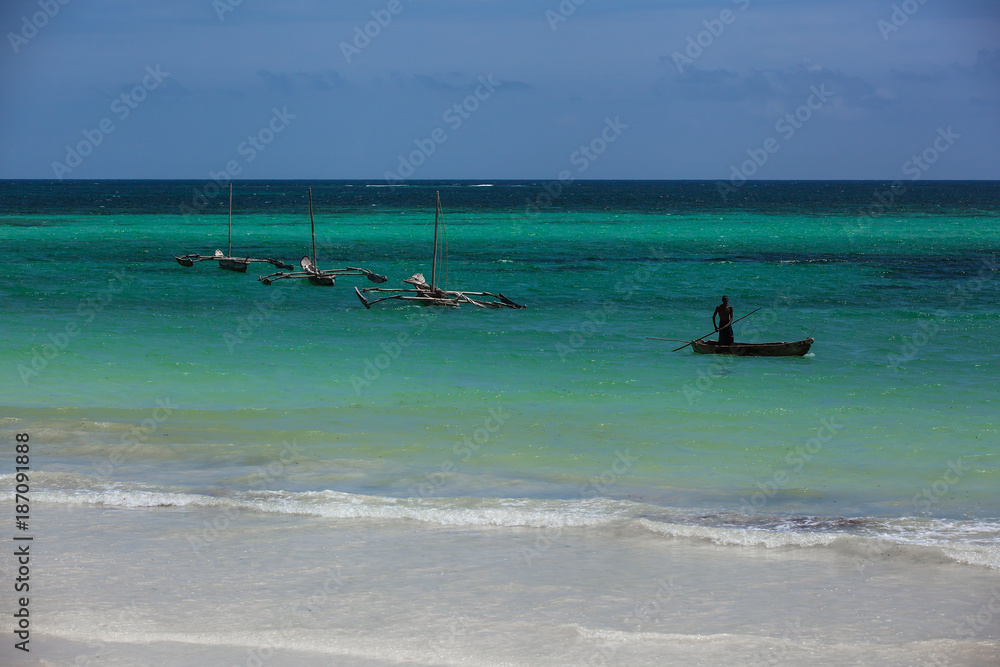 male fisherman floats on a wooden boat in the ocean, Wooden boat on the waves of the ocean, fisherman, Coast of Mombasa, Kenya, ocean, clouds, coast