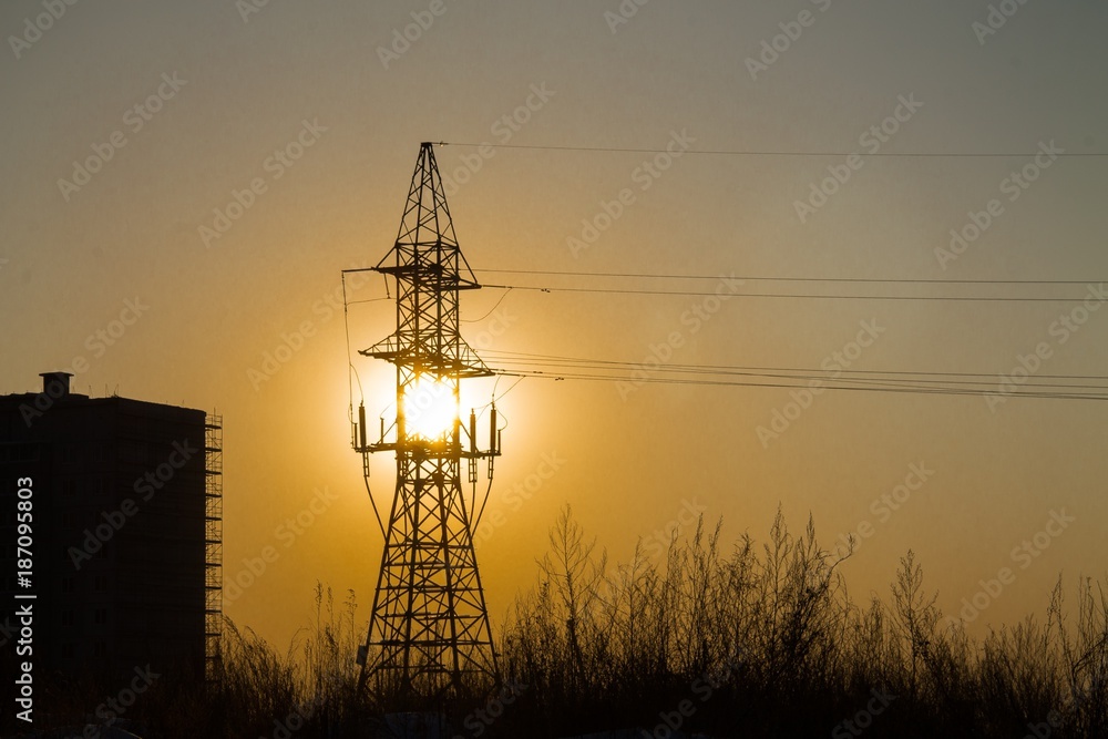 a line tower wth the sun behind it during the sunset