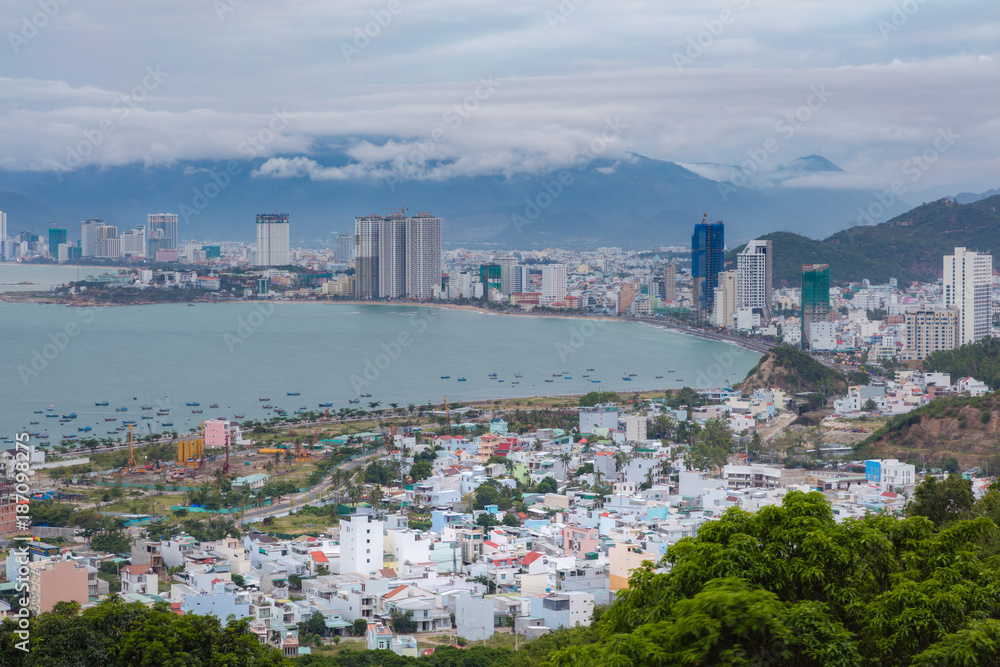 Holiday resort Nha Trang Vietnam on a cloudy day from a view point north of the city. With the mountains in the background and the turquoise south china sea to the left.