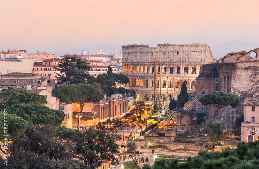 Panoramic view of Colosseum and ruins in the city center of Rome at sunset, Italy.