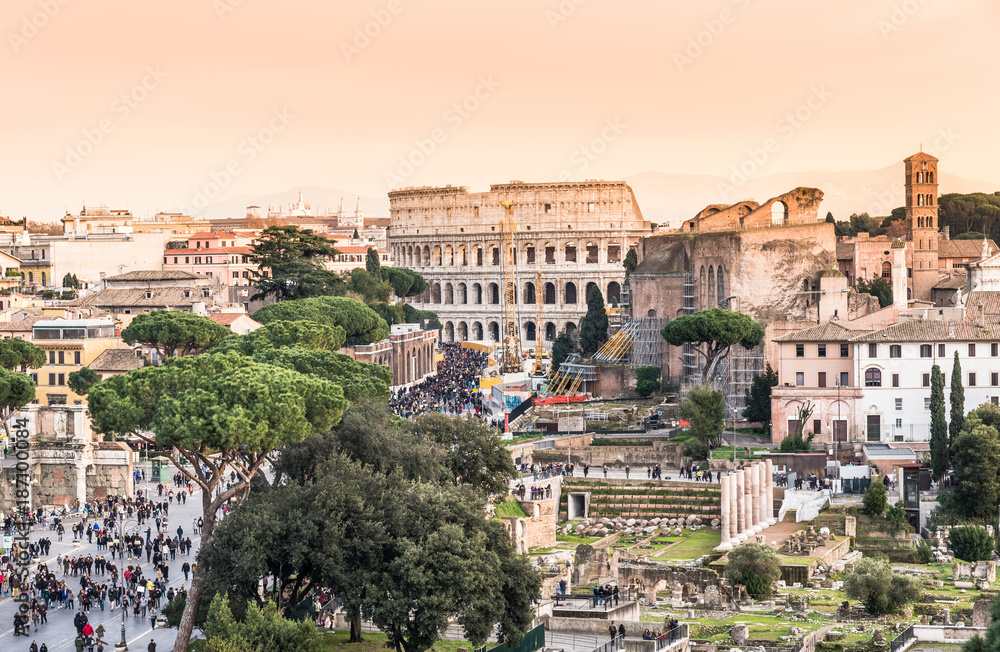 Panoramic view of Colosseum and ruins in the city center of Rome at sunset, Italy.