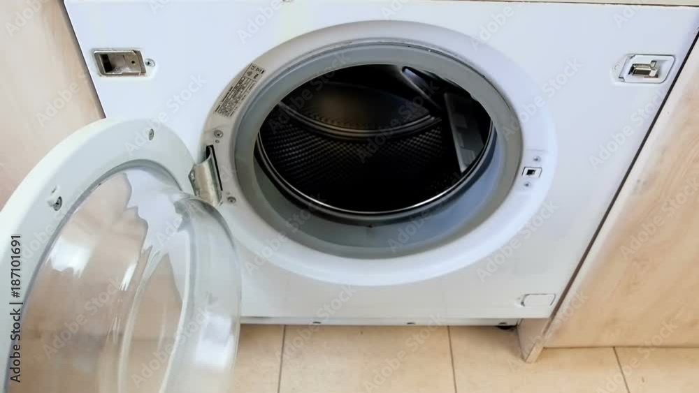 Slow motion video of young female hand throwing dirty clothes in washing machine at laundry Slow motion video of young female hand throwing dirty clothes in washing machine at laundry