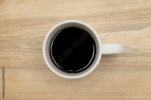 top view of a coffee cup on rustic wooden pale brown background