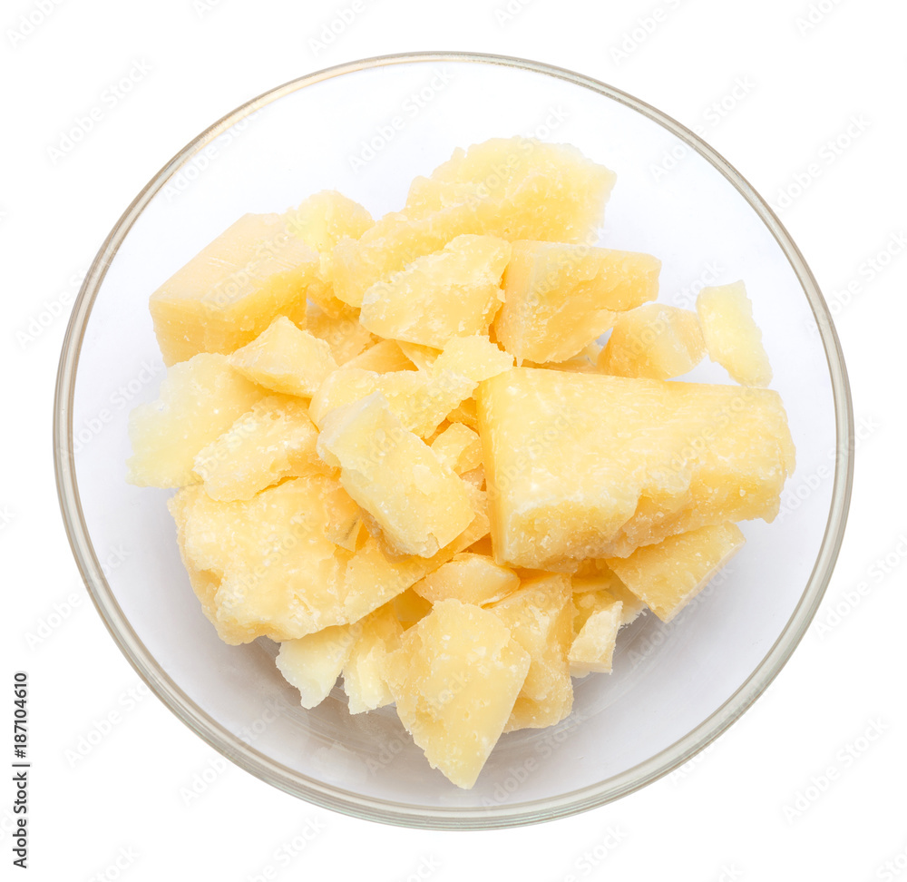 Parmesan cheese pieces in glass bowl on white background Parmesan cheese pieces in glass bowl on white background