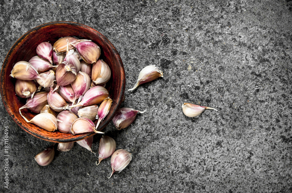 Peaces of fresh garlic in a wooden bowl.